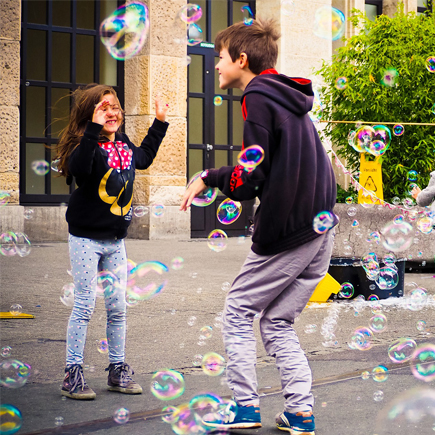En pojke och en flicka blåser såpbubblor utomhus