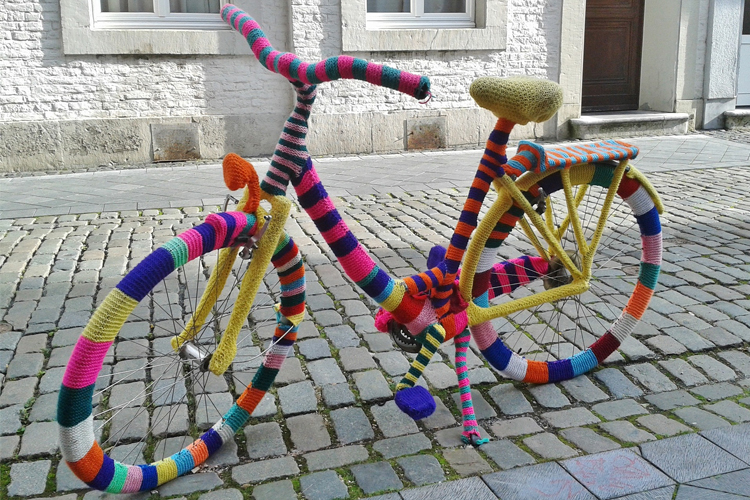 Handarbetsgruppen Symamsellerna En cykel som är helt beklädd med stickning i granna färger.