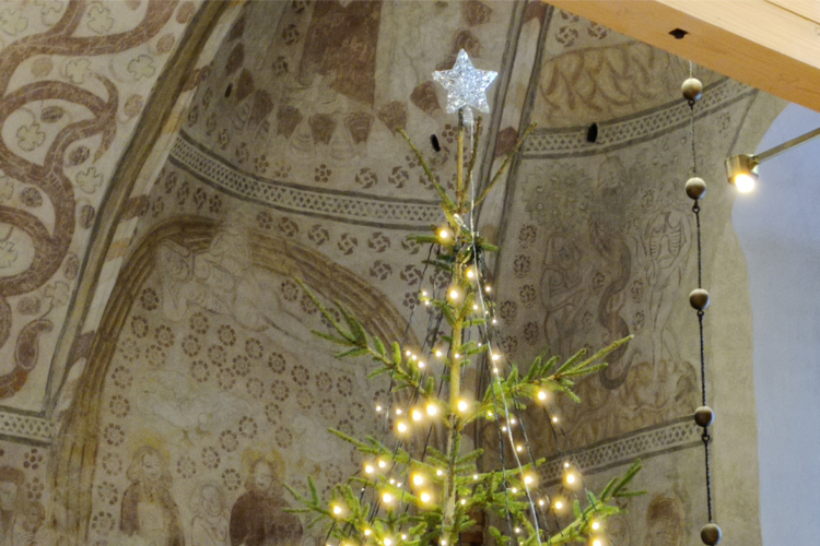 Julbön med små och stora Julgran med tända ljus i Esbo domkyrka.