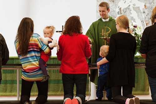 Barn och vuxna i kyrkan.