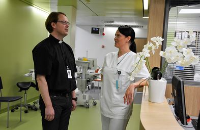 Sjukhuspräst och sjukskötare på en avdelning.