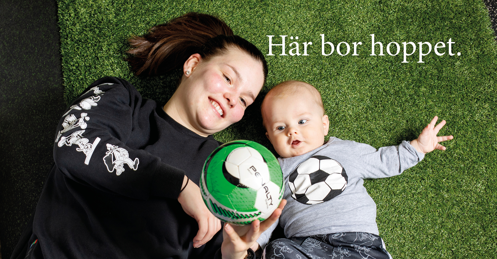 Ung kvinna på en gräsmatta med en fotboll och en baby.