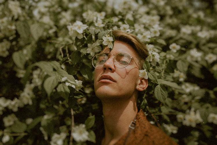 Ung man under ett blommande träd.