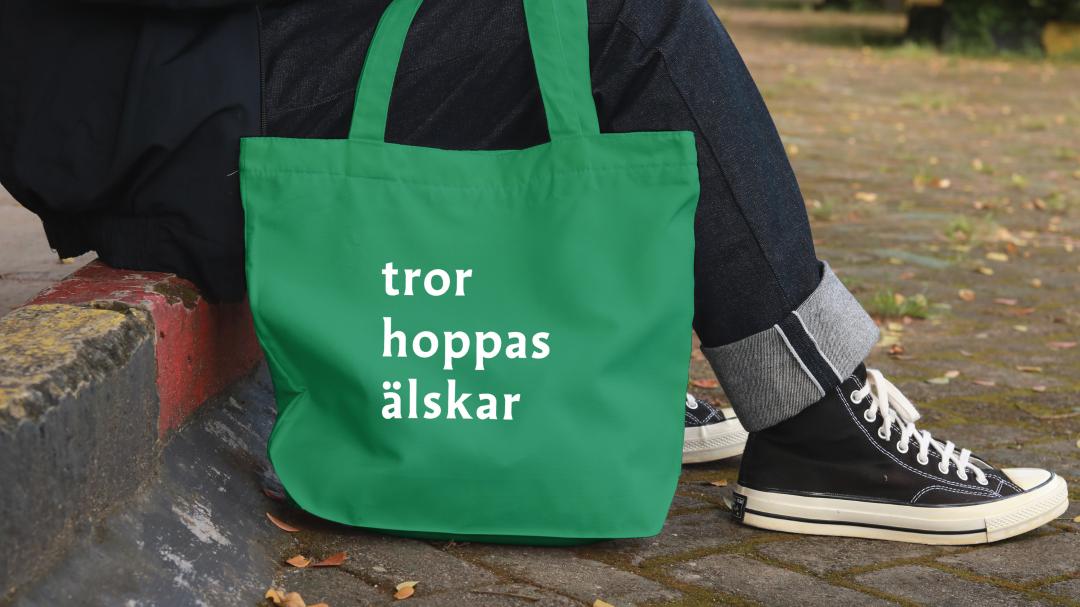 En tygkasse med text tror, hoppas, älskar
